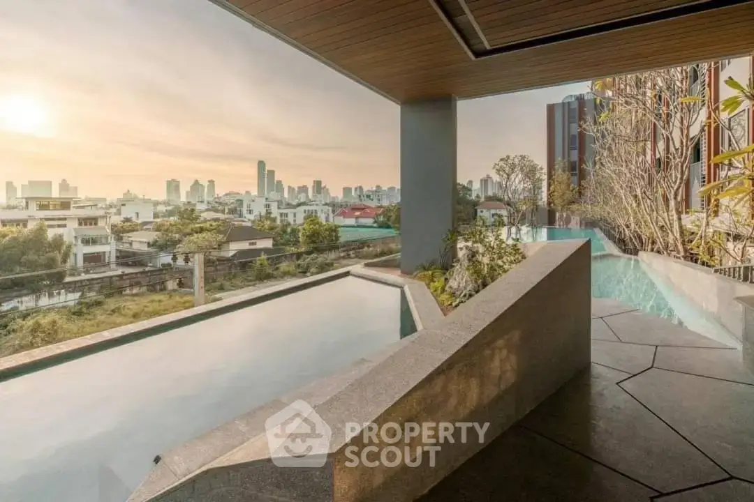Luxurious rooftop pool with stunning city skyline view at sunset, perfect for relaxation and entertainment.