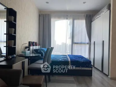 Cozy bedroom with modern decor and large window offering ample natural light.