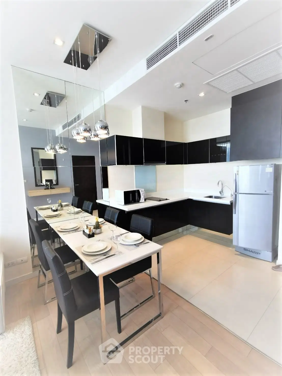 Modern kitchen with sleek black cabinetry and dining area in a stylish apartment.