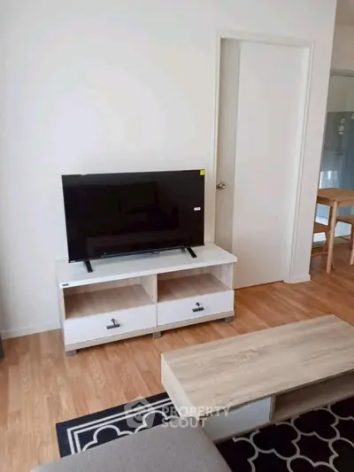 Modern living room with sleek TV stand and wooden flooring, perfect for cozy gatherings.