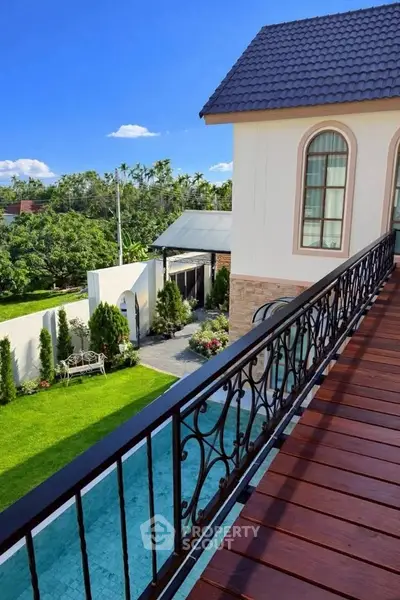 Luxurious home with elegant balcony overlooking lush garden and pool