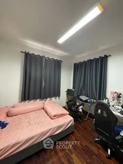 Cozy bedroom with wooden flooring and modern furnishings, perfect for a comfortable living space.