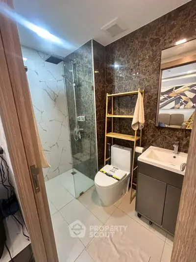 Modern bathroom with glass shower and stylish vanity in luxury apartment.