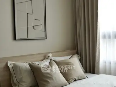 Elegant bedroom with neutral tones and modern decor, featuring a cozy bed and stylish wall art.