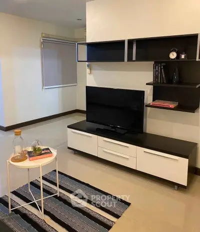 Modern living room with sleek TV unit and stylish decor in a cozy apartment.