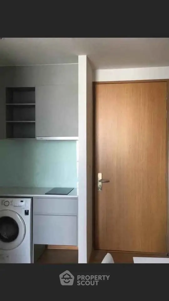 Modern apartment interior with washing machine and sleek cabinetry