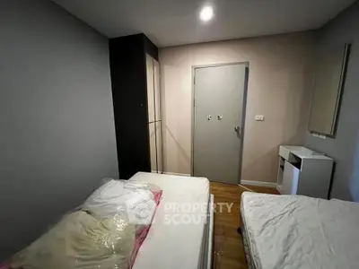 Cozy bedroom with twin beds and modern decor, perfect for a comfortable stay.