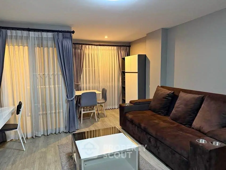 Modern living room with cozy brown sofa, stylish coffee table, and elegant dining area.