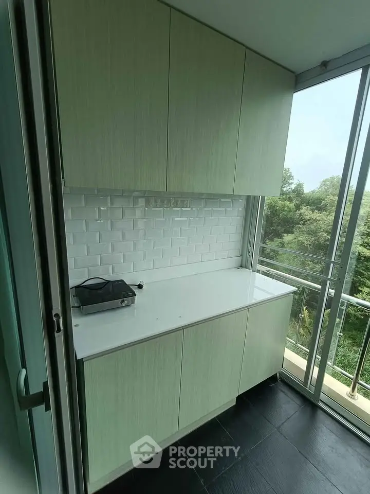 Modern kitchen with sleek cabinetry and scenic balcony view