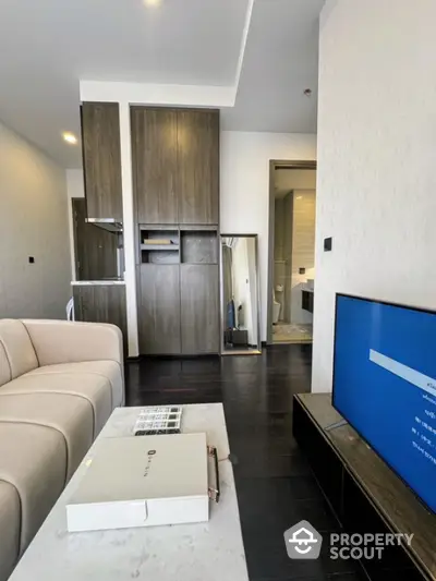 Modern living room with sleek furniture and open layout, featuring a stylish TV setup and elegant decor.