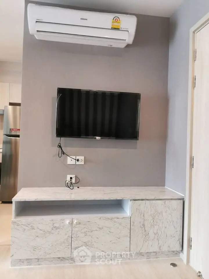 Modern living room with sleek TV setup and air conditioning, perfect for comfortable living.