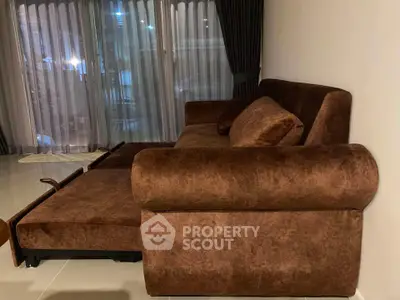 Luxurious brown velvet sofa in a modern living room with floor-to-ceiling windows.