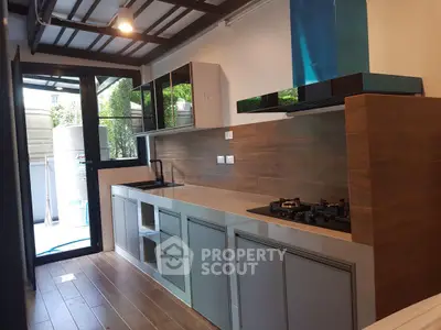 Modern kitchen with sleek design, featuring gas stove and ample storage space.