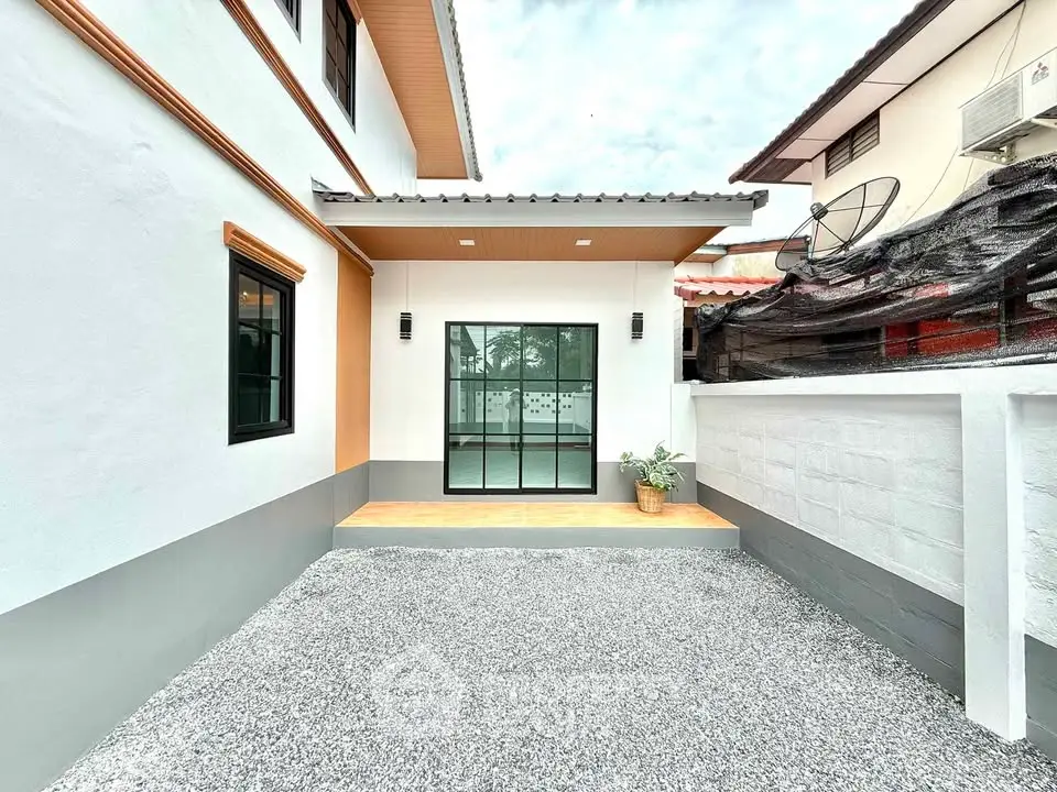 Charming modern exterior with gravel courtyard and sleek windows