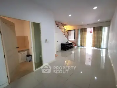 Spacious living room with modern staircase and large windows