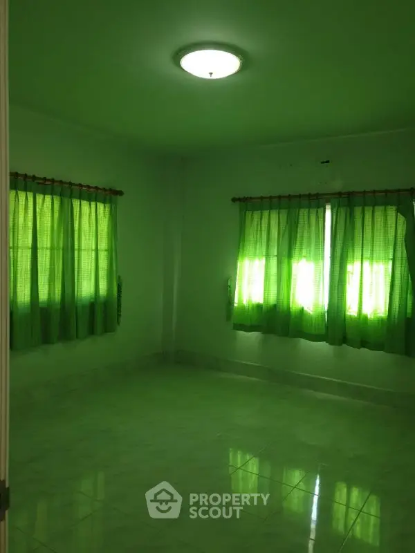 Spacious room with green curtains and tiled floor, ideal for customization.