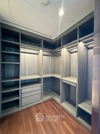Spacious walk-in closet with elegant wooden shelving and ample storage space