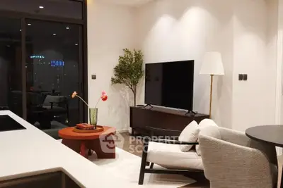 Modern living room with sleek furniture and large TV, perfect for relaxation and entertainment.