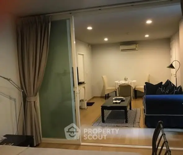 Modern living room with cozy seating and dining area, featuring elegant lighting and stylish decor.