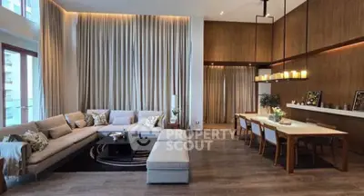 Luxurious open-plan living and dining area with modern decor and high ceilings.