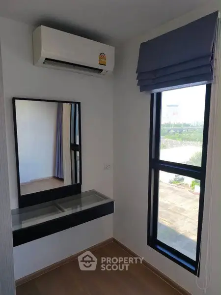 Modern room with air conditioning and large window offering natural light and scenic view.