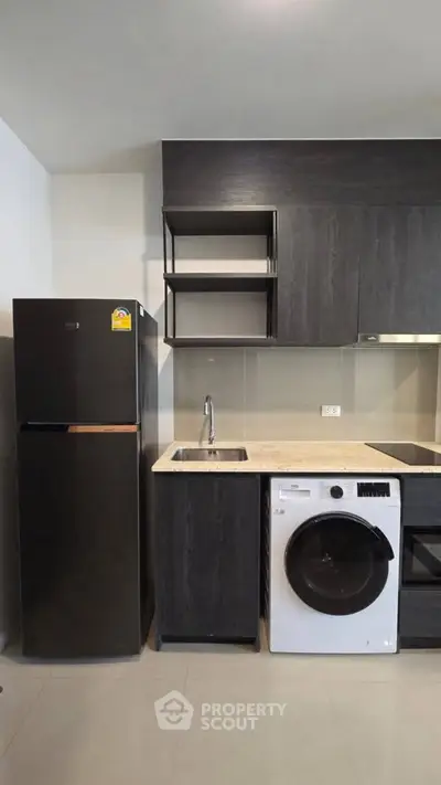 Modern kitchen with sleek black appliances and washing machine