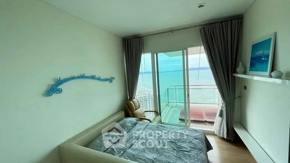 Stunning bedroom with ocean view and balcony access in modern high-rise apartment.