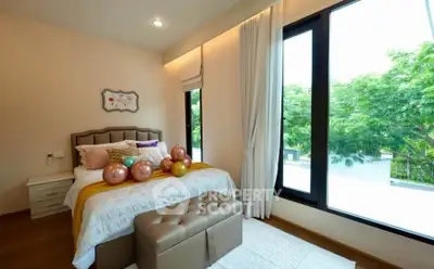 Elegant bedroom with large windows and modern decor, featuring a cozy bed and lush greenery view.