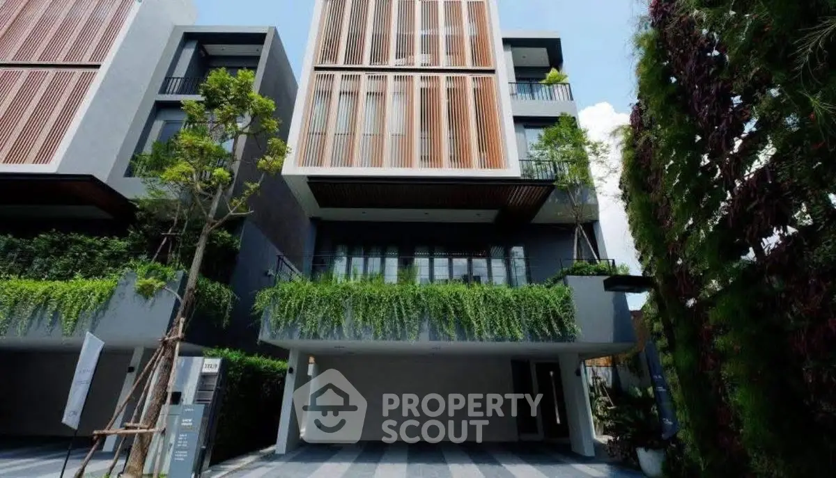 Modern architectural building with lush greenery and spacious design.
