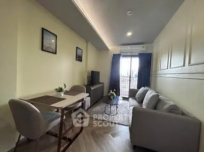 Modern living room with stylish decor and natural light, featuring a cozy sofa and dining area.