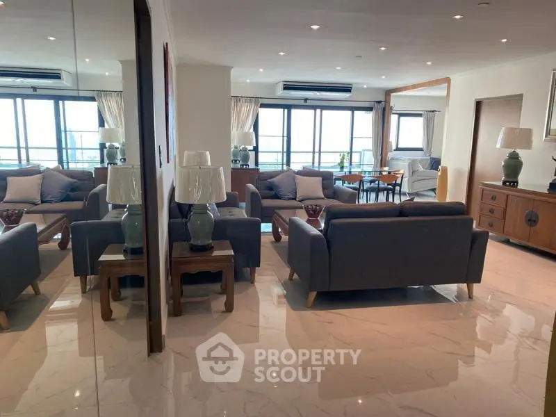 Spacious modern living room with elegant furniture and large windows offering natural light.