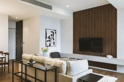 Modern living room with stylish decor and wall-mounted TV, featuring elegant wood paneling and cozy seating.