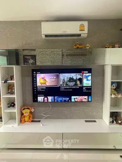 Modern living room with wall-mounted TV and air conditioning, featuring stylish shelving and decor.