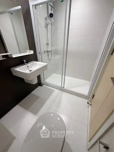 Modern bathroom with sleek shower enclosure and contemporary fixtures.