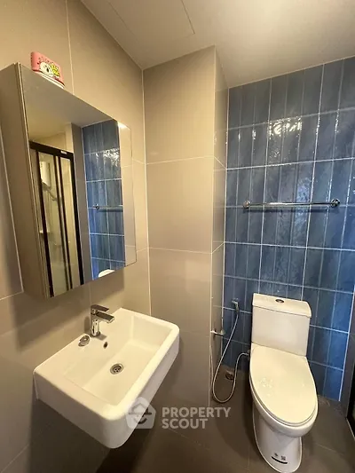 Modern bathroom with sleek sink and blue tiled wall
