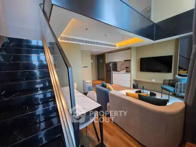 Luxurious modern living room with open kitchen and stylish staircase in a duplex apartment.