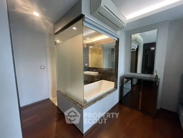 Modern bathroom with glass-enclosed bathtub and sleek design