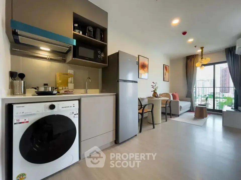 Modern open-plan kitchen and living room with sleek appliances and stylish decor.