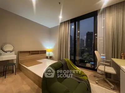 Modern bedroom with city view, featuring stylish furniture and large windows for natural light.