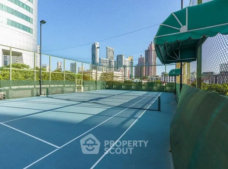 Spacious urban tennis court with city skyline views, perfect for sports enthusiasts seeking a vibrant lifestyle.