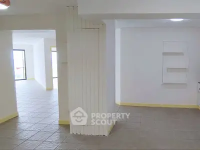 Spacious open-plan interior with tiled flooring and ample natural light, perfect for modern living.