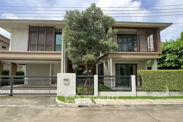Modern two-story house with lush greenery and sleek design in a serene neighborhood.