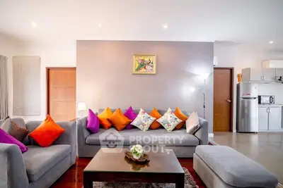 Spacious living room with colorful cushions and modern kitchen in open layout
