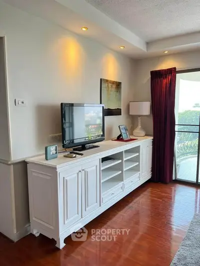Charming living room with elegant TV stand and balcony view