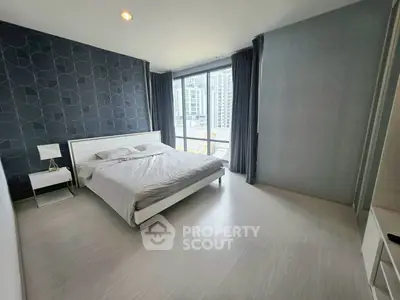 Modern bedroom with stylish decor and large window offering city view