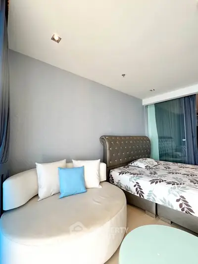 Modern bedroom with stylish round sofa and elegant bed in bright natural light.