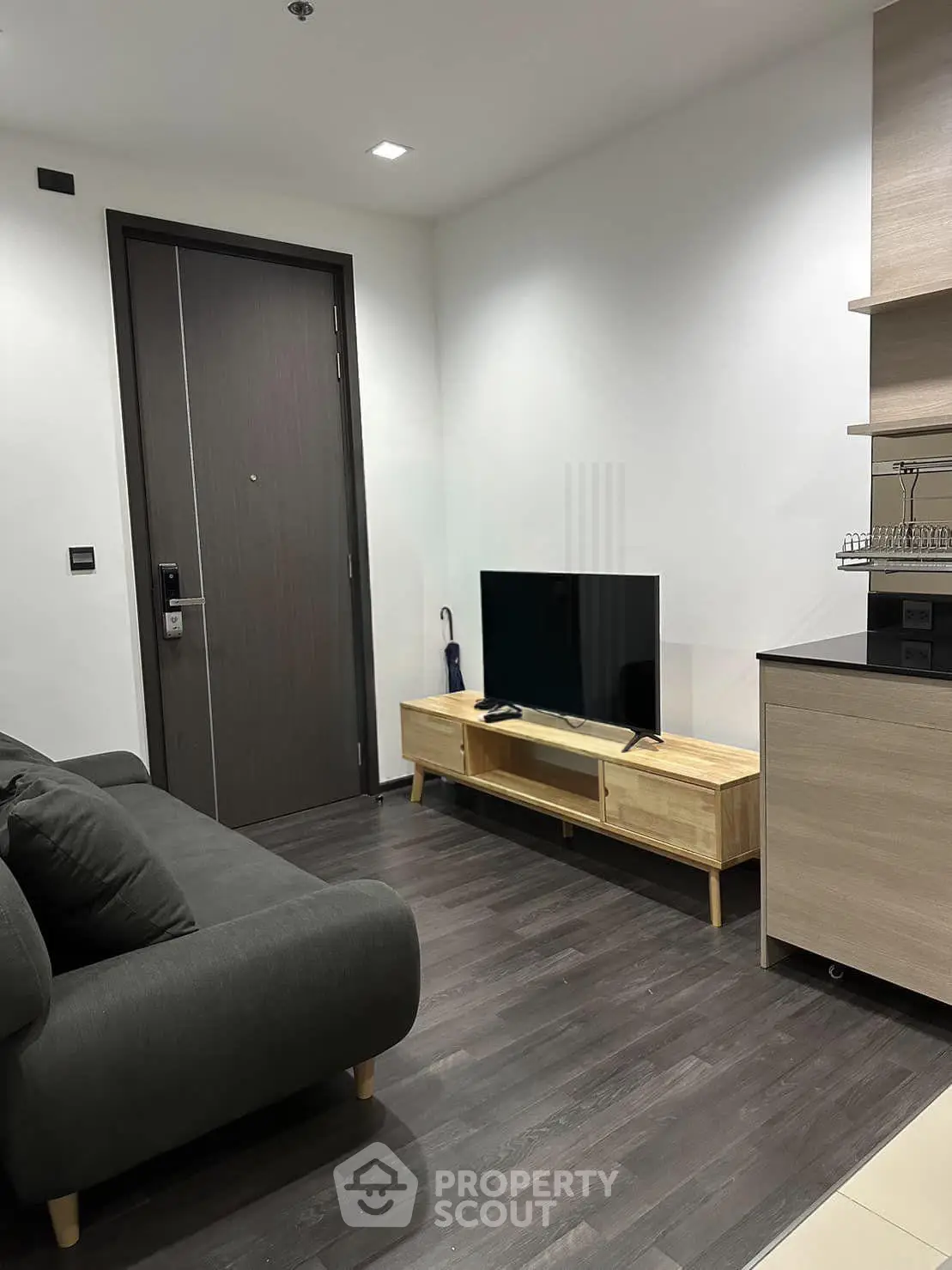 Modern living room with sleek furniture and flat-screen TV in a stylish apartment.