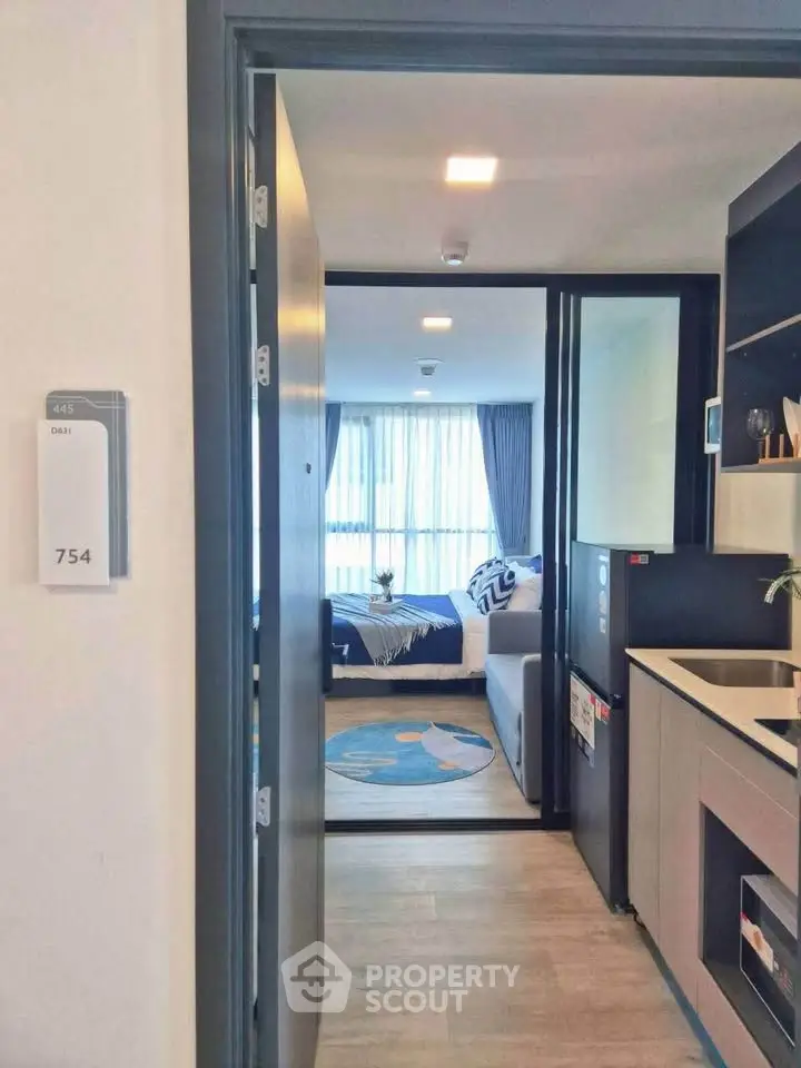 Modern apartment entrance leading to a cozy living room with stylish decor and natural light.