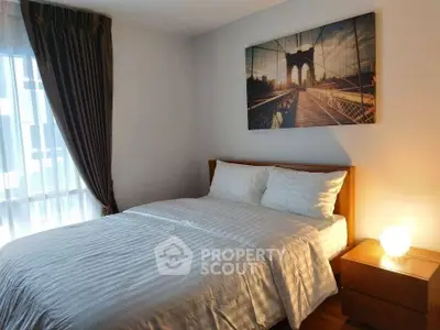 Cozy bedroom with elegant decor and large window for natural light.