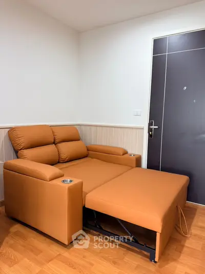 Modern living room with stylish brown leather recliner sofa and wooden flooring.